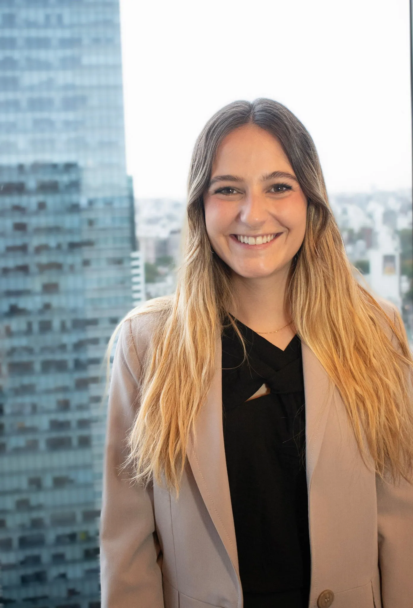 Retrato profesional de Lucía Amondarain, consultora en InvestaTrust, con un fondo de edificio moderno.