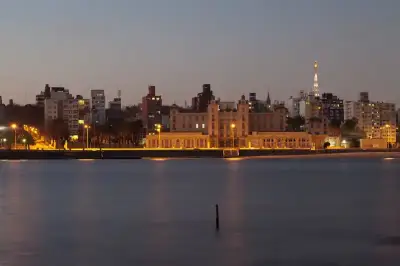 Vista urbana nocturna junto al agua, utilizada como portada de una nota sobre Uruguay.