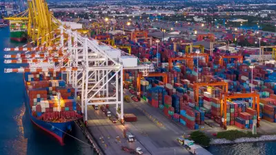 Puerto de contenedores y grúas, representando comercio internacional, aranceles y gestión de riesgos.