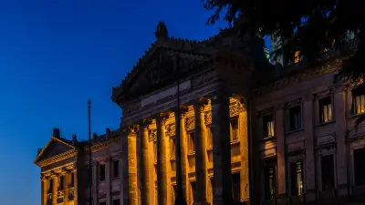 Edificio institucional iluminado de noche en Uruguay, portada de una nota sobre posibles cambios fiscales.