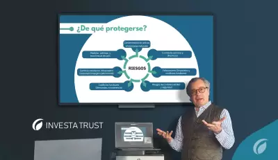 Hombre de pie junto a una presentación sobre riesgos en la gestión patrimonial, mostrando gráficos en una pantalla.
