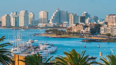 Vista costera de una ciudad uruguaya con edificios y puerto deportivo.