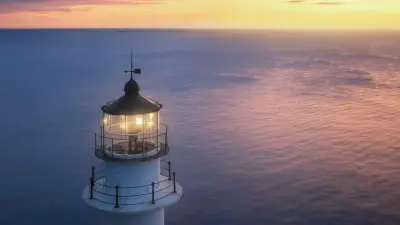 Faro sobre el mar al atardecer, símbolo de orientación al estructurar un trust.