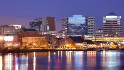 Vista urbana de una ciudad estadounidense junto al agua, asociada a una nota sobre Delaware y los trusts.