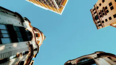 Vista hacia el cielo entre edificios modernos, asociada a oportunidades de residencia y desarrollo en Uruguay.