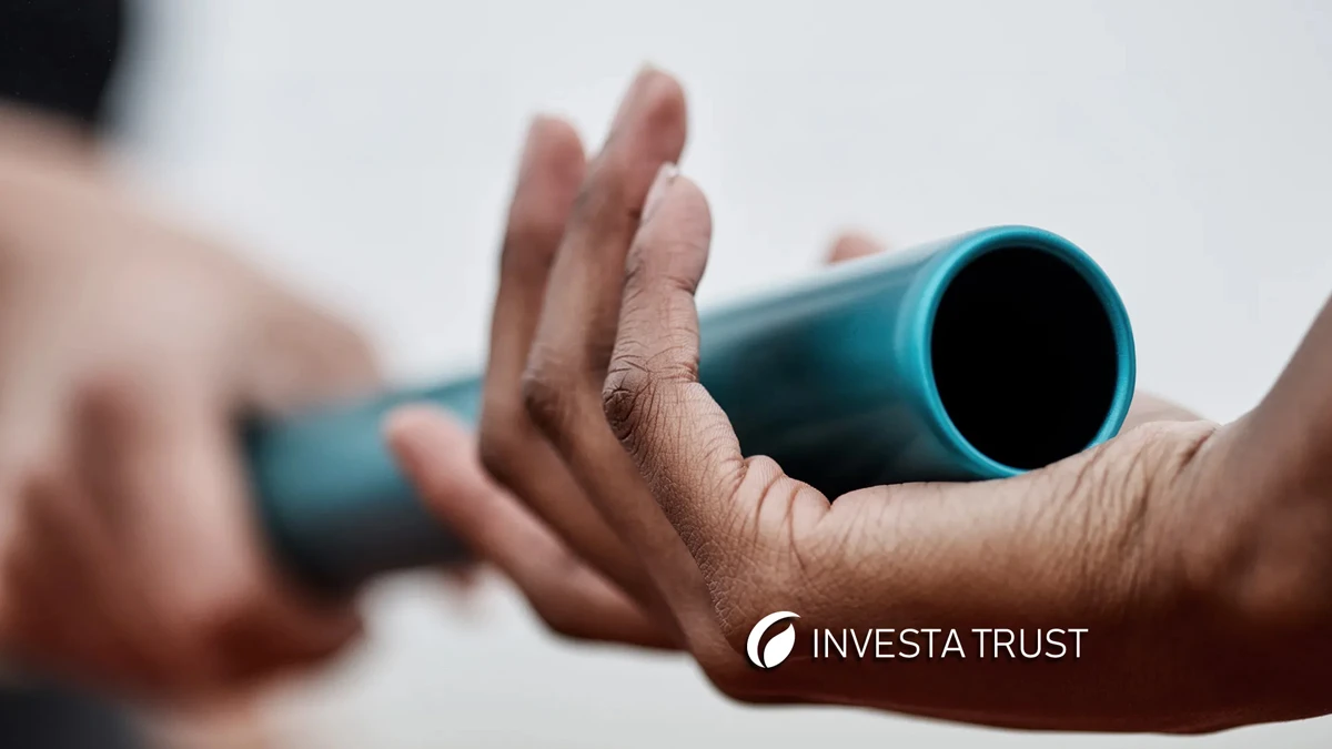 Primer plano de un relevo de testigo entre dos manos, simbolizando el traspaso de responsabilidades y patrimonio, representando la planificación para una transición generacional exitosa con InvestaTrust.